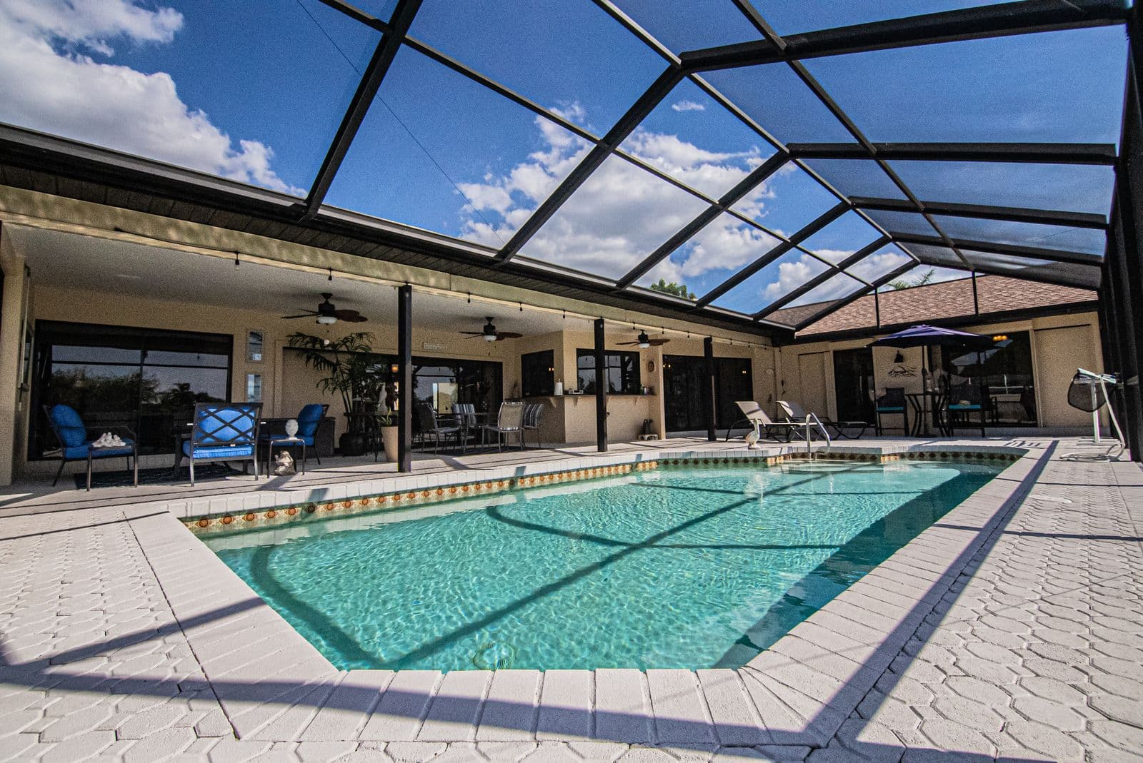 A screened pool enclosure with lanai seating at a Florida vacation home